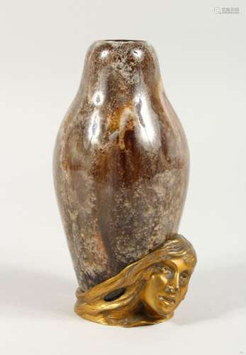 AN UNUSUAL SMALL TREACLE GLAZED POTTERY VASE, the base with applied bronze female bust, signed