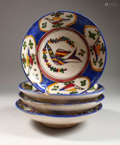 A SET OF FOUR ISLAMIC POTTERY BOWLS, each painted with stylised birds. 9.5ins diameter.