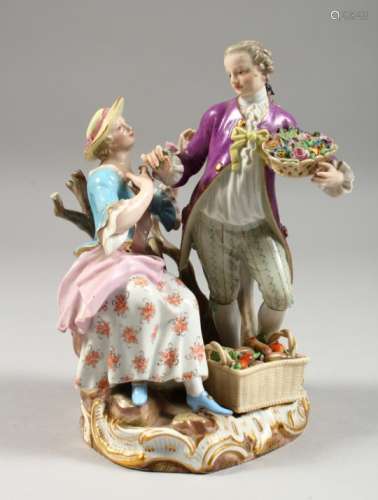 A MEISSEN FIGURE GROUP OF A GARDENER AND LADY, the man holding a basket of flowers, the lady