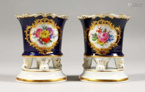 A PAIR OF MEISSEN SMALL SPILL VASES, blue ground, painted with a panel of flowers on scrolling