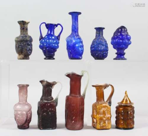 A COLLECTION OF ROMAN GLASS BOTTLES, some with moulded decoration as heads, bunches of grapes (10).