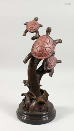 AN UNUSUAL BRONZE MODEL OF THREE TURTLES, on a circular marble base. 16ins high.