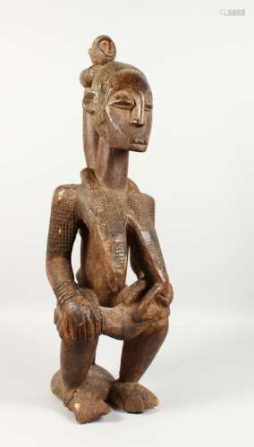 A LARGE CARVED WOOD TRIBAL FIGURE, of a mother with suckling baby and two further children on her