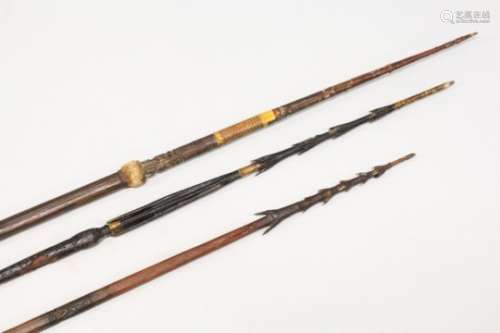 THREE SOLOMON ISLANDS CARVED BARBED SPEARS, two early shorter examples, each with carving to the
