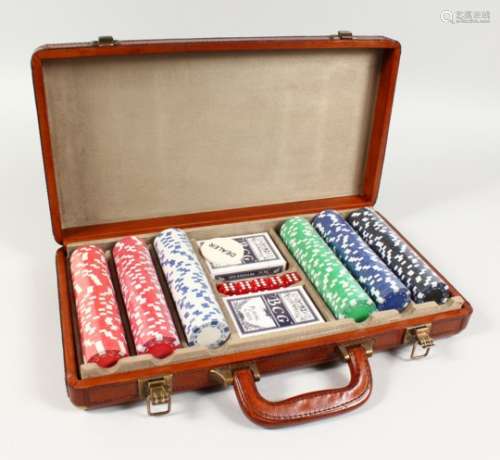 A LEATHER CASED GAMING SET, including playing cards, chips and dice. 16ins wide.