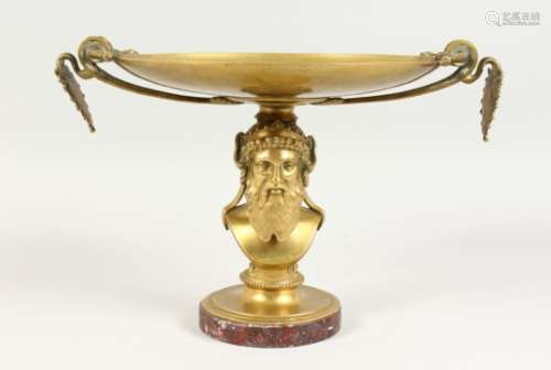 A GREEK STYLE BRASS TAZZA, the engraved circular top with anthemion handles, on a male bust column