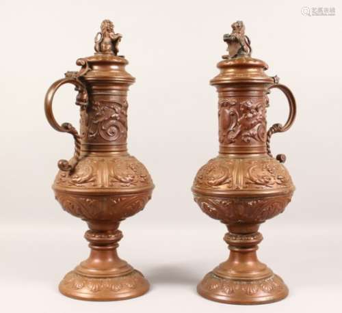 A LARGE PAIR OF CONTINENTAL EMBOSSED COPPER PEDESTAL EWERS, the hinged lids mounted with a lion