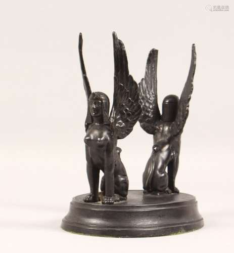 A SPELTER STAND, modelled as a pair of winged sphinx on an oval base. 7.5ins wide.