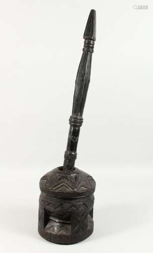 A GOOD AFRICAN CARVED HARDWOOD PESTLE AND MORTAR, with long turned and carved shaft and drum