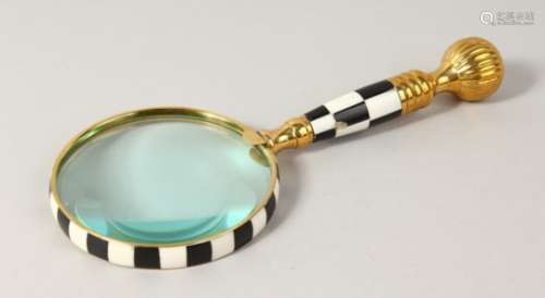 A MAGNIFYING GLASS with chequered handle.