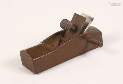 A SMALL BRONZE MODEL, of a carpenters plane. 3.25ins long.