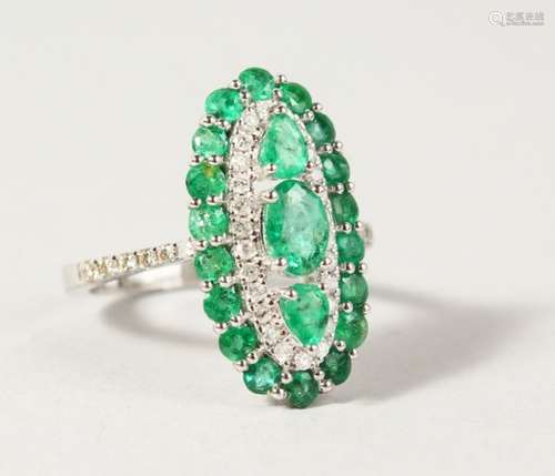 A GOOD 18CT GOLD, EMERALD AND DIAMOND SET OVAL RING.