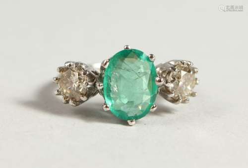 AN IMPRESSIVE 18CT WHITE GOLD, EMERALD AND DIAMOND THREE-STONE RING, central emerald with diamonds.