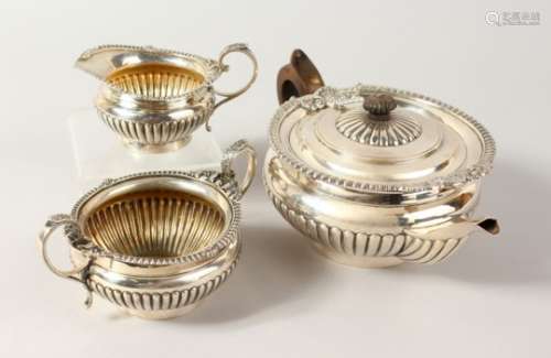 A THREE PIECE TEA SERVICE, comprising teapot, milk jug and sugar bowl, all with ribbed bodies.