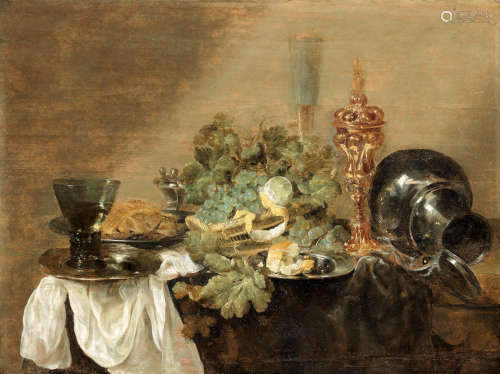 Abraham Hendricksz. van Beyeren(The Hague 1620-circa 1690 Overschie) Grapes and a peeled lemon in a basket with bread, dressed crab and a roemer of wine on pewter plates, together with a gilt cup and cover, and a pewter flagon upon a draped table-top unframed