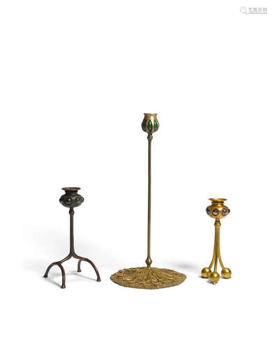 Group of Three Candlestickscirca 1910patinated bronze, Favrile glass, each stamped with the firm's marksheight of tallest 17 1/2in (44cm); diameter of base 8in (20cm)  Tiffany Studios (1899-1930)