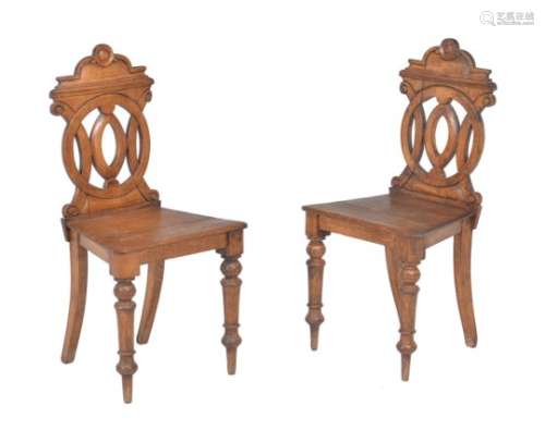 A pair of Victorian oak hall chairs