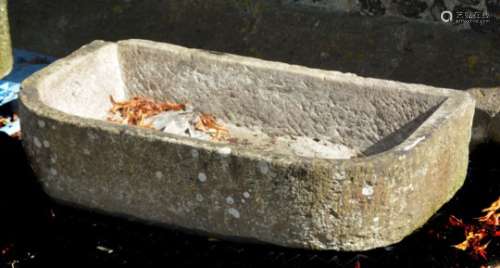 A rough hewn stone trough or basin