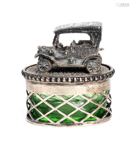 A small oval green glass mustard jar with veteran motoring scene lid,
