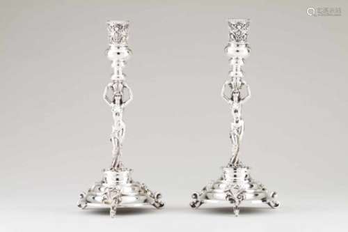 A pair of candlesticksEuropean silverNude female figure shaft with head basket and turned candle