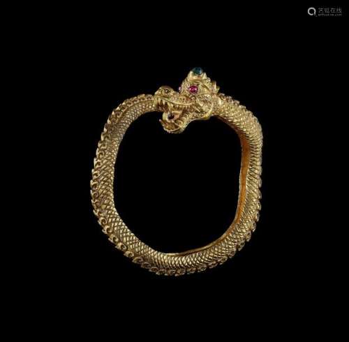 A GOLD DRAGON BANGLE WITH RUBY EYES AND A GREEN GE…