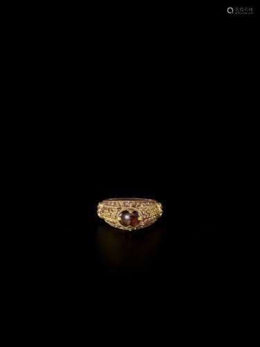 A CHAM REPOUSSÉ GOLD RING WITH A GEMSTONE