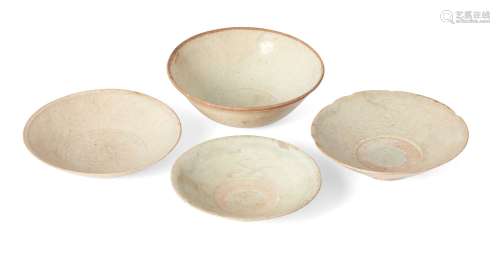 Four Chinese porcelain bowls, Yuan dynasty, each with pale blue translucent glaze, three with carved