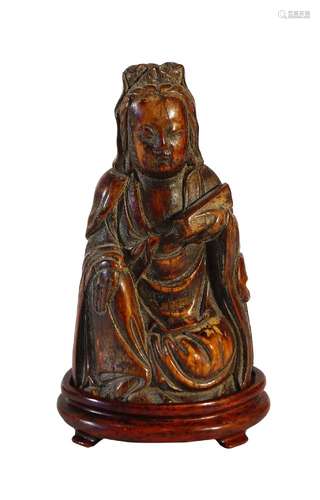 A Chinese ivory carving of Guanyin, Ming dynasty, carved seated holding a scroll box in her left