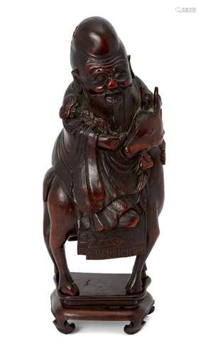 A Chinese bamboo figure of Shou Lao, 19th century, carved atop a deer, holding a ruyi-sceptre, on