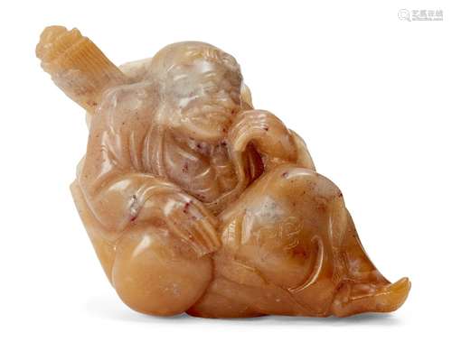 A Chinese carved soapstone figure, late Qing dynasty, carved as a seated deity with a lotus leaf