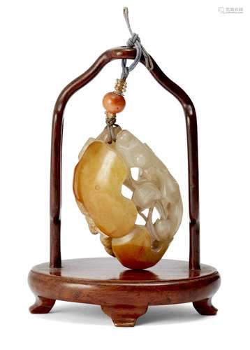 A Chinese celadon and russet jade pendant, 19th century, carved with a goldfish amidst a lotus, 5.