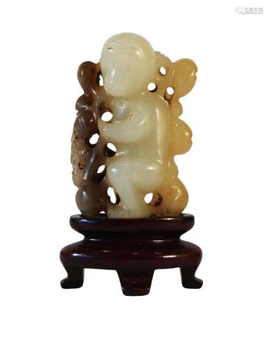 A Chinese pale green jade monkey carving, late Qing dynasty, carved as a monkey holding a fruiting