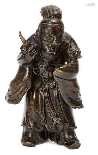 A Chinese bronze figure, 20th century, depicting a robed man holding a dagger, 21cm high 20世紀