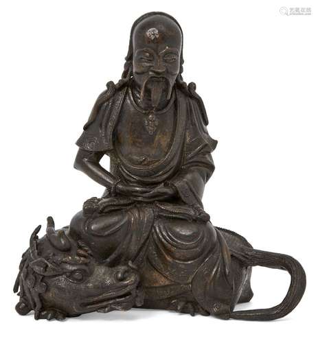 A Chinese bronze figure of a deity atop a quilong dragon, Ming dynasty, 17th century, the deity