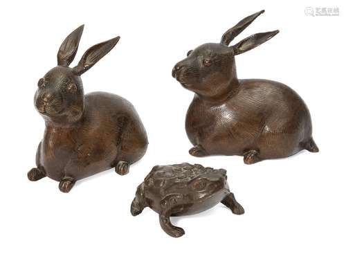 Two Japanese bronze rabbits and a toad, Meiji period, the rabbits with etched fur, alert ears and