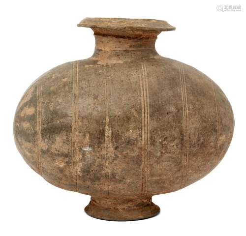 A Chinese grey pottery 'cocoon' jar, Han dynasty, decorated with linear bands raised on spreading