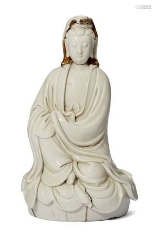 A Chinese Dehua figure of Guanyin, 17th century, modelled seated, wearing flowing robes and with