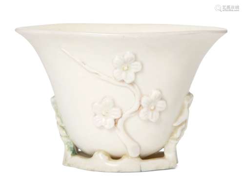 A Chinese Dehua libation cup, 17th century, moulded with flowering prunus blossom, 7.5cm high 17世紀