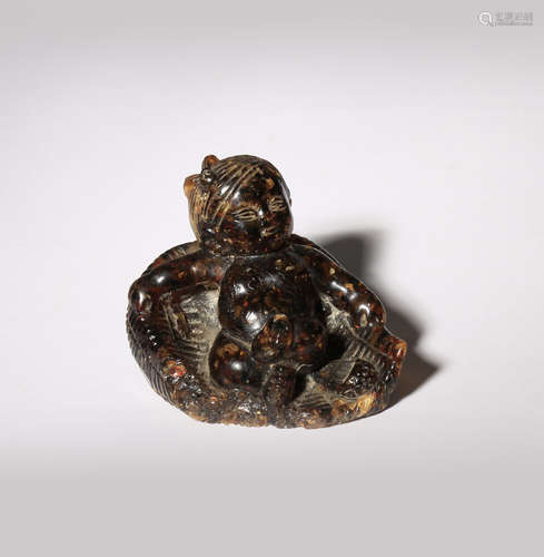 A RARE CHINESE AMBER CARVING OF AN INFANT IN A BASKET