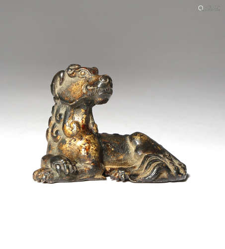 A CHINESE GILT-LACQUERED BRONZE MODEL OF A RECUMBENT CANID