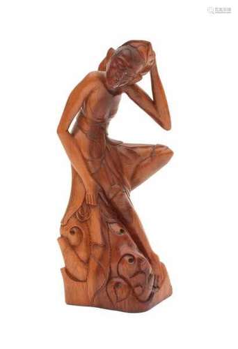 An Indonesian hardwood sculpture, a figure of a man sitting on some rocks. Circa 1930height 26