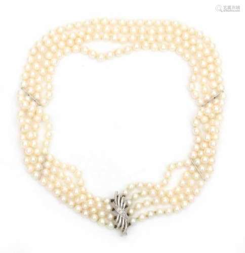 A three strand cultured pearl choker or 'necklace de chien' with a 14 carat white gold clasp, set
