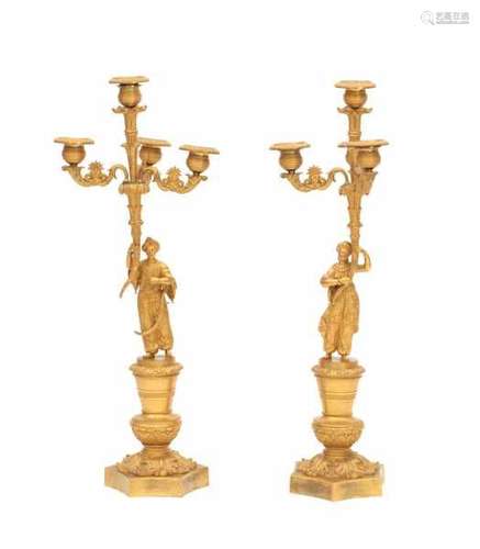 A pair of gilt-bronze four-light candelabra. 19th century. With a male and female figure in