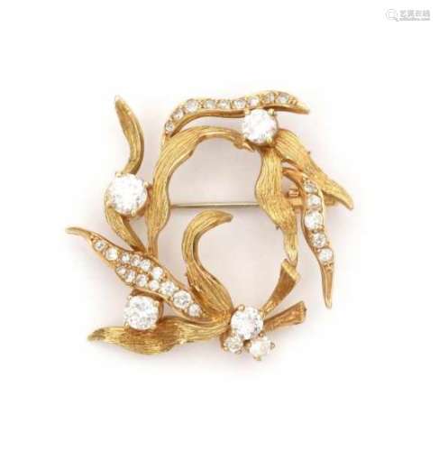 An 18 krt yellow gold circular brooch of floral or leaf design, from the 1970's. Set with