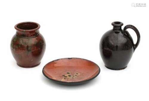 A collection of North American pottery. A black glaze jug, a green and brown glazed jar, and an