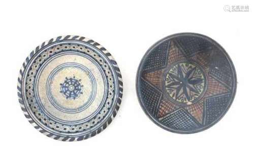 Two Dutch Majolica plates. One decorated with a coloured star, the other with a pattern in blue.