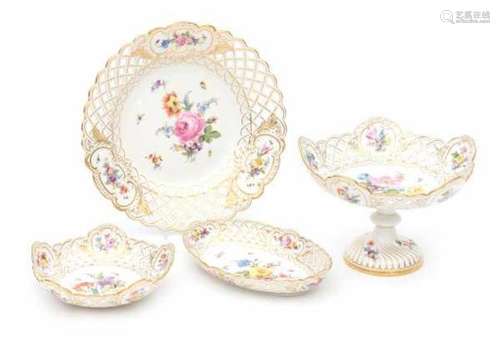 Four pierced porcelain serving dishes, one footed, all decorated with a variety of flowers. Marked