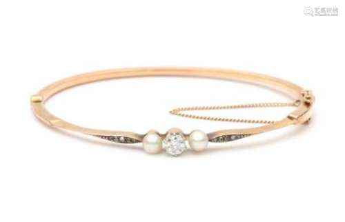 A 14 krt rose gold hinged bracelet. Late 19e - early 20e century. Set with two cultured pearls, an