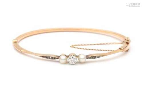 A 14 krt rose gold hinged bracelet. Late 19e - early 20e century. Set with two cultured pearls, an