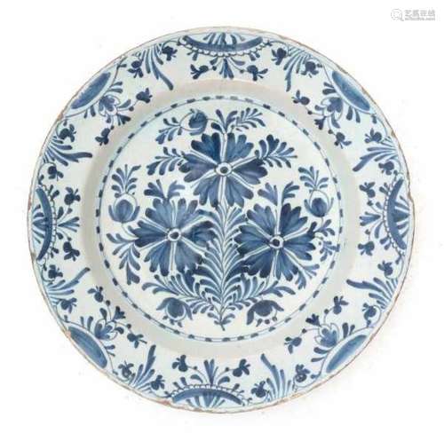 A Delft blue and white charger, decorated with a floral pattern. 18th century.Diameter 35 cm.- - -